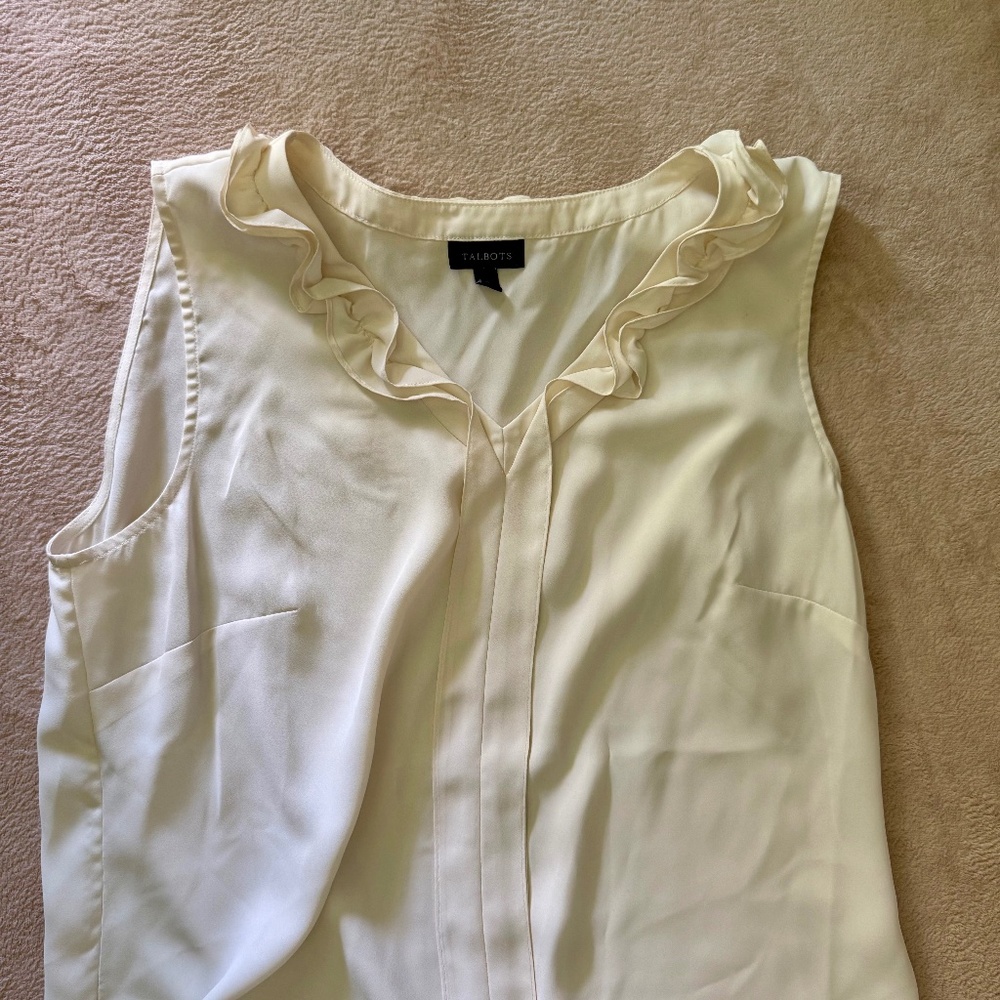 Cream v-neck shirt with ruffle detail.